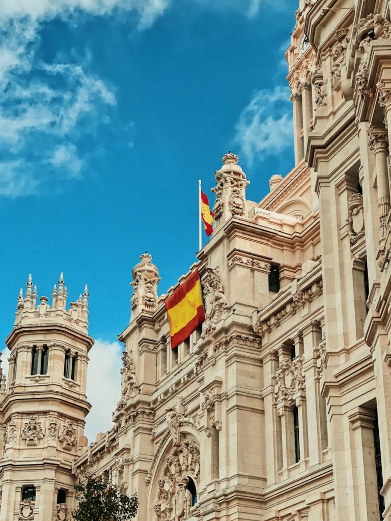 yellow and red flag hanging on white building